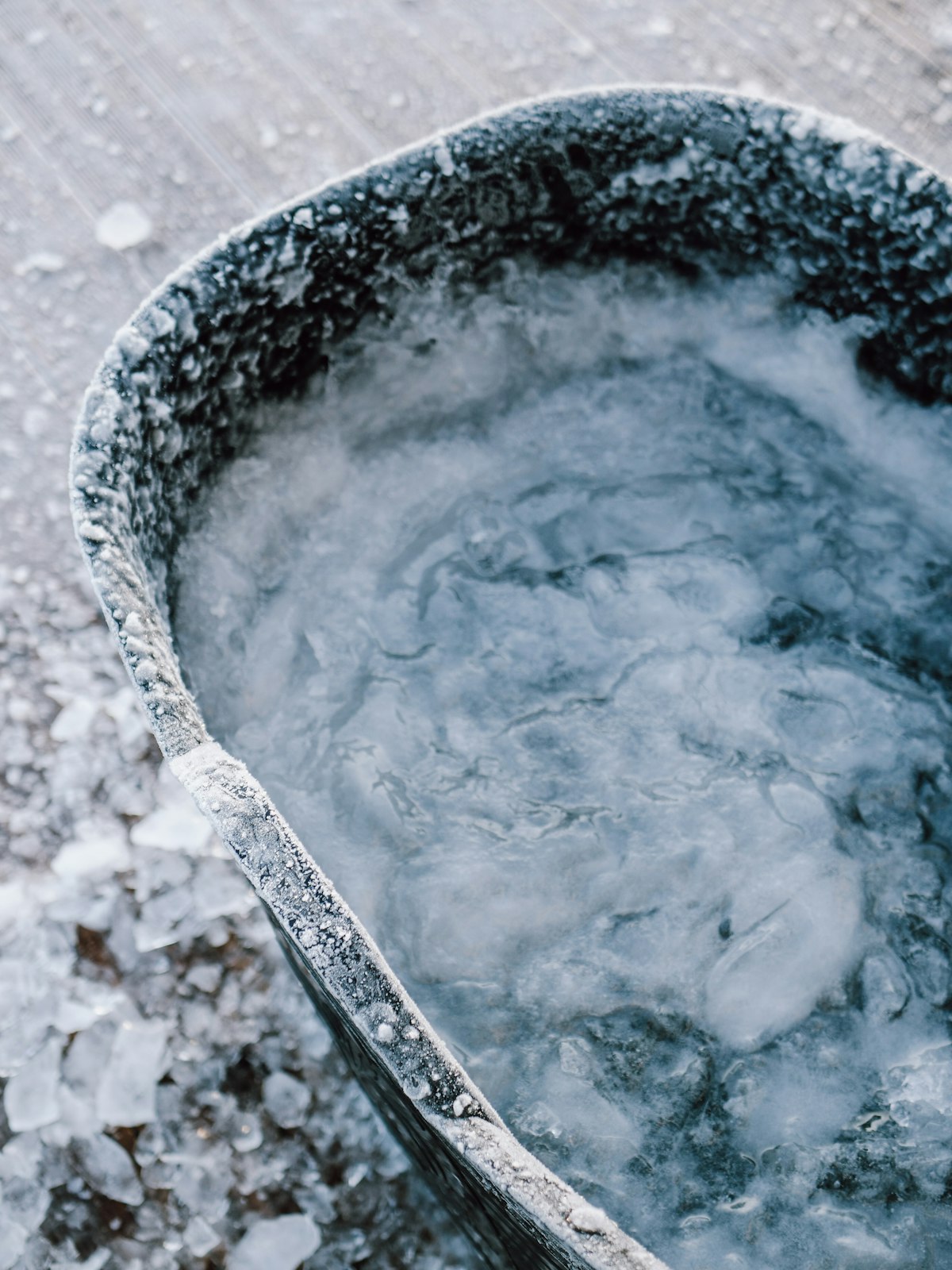 Bassine métallique remplie d'eau glacée, éclats de glace autour