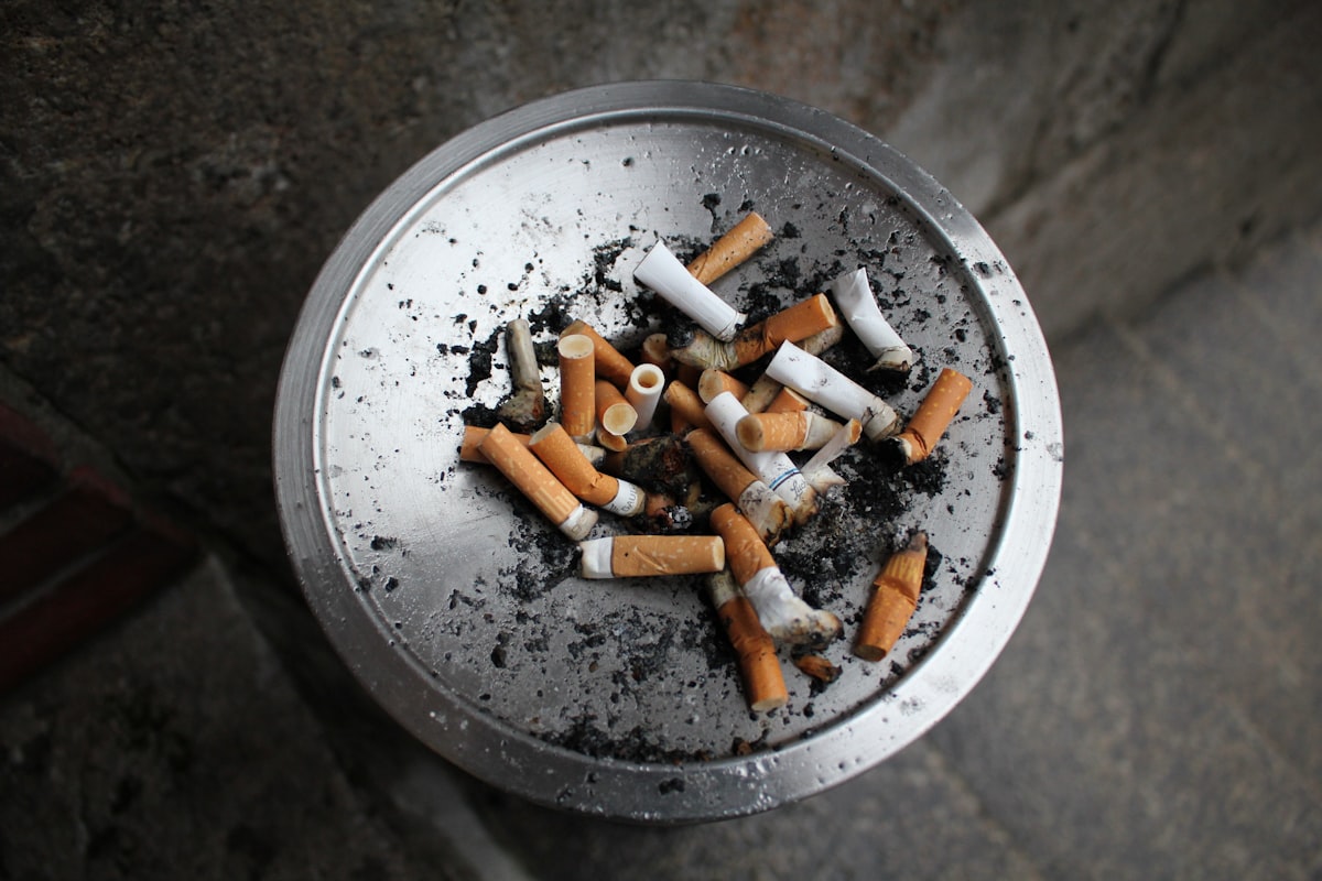 Cendrier métallique rempli de mégots de cigarettes