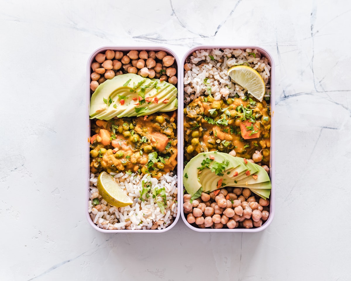 Deux repas préparés à l'avance dans des boîtes : riz, pois chiches, avocat