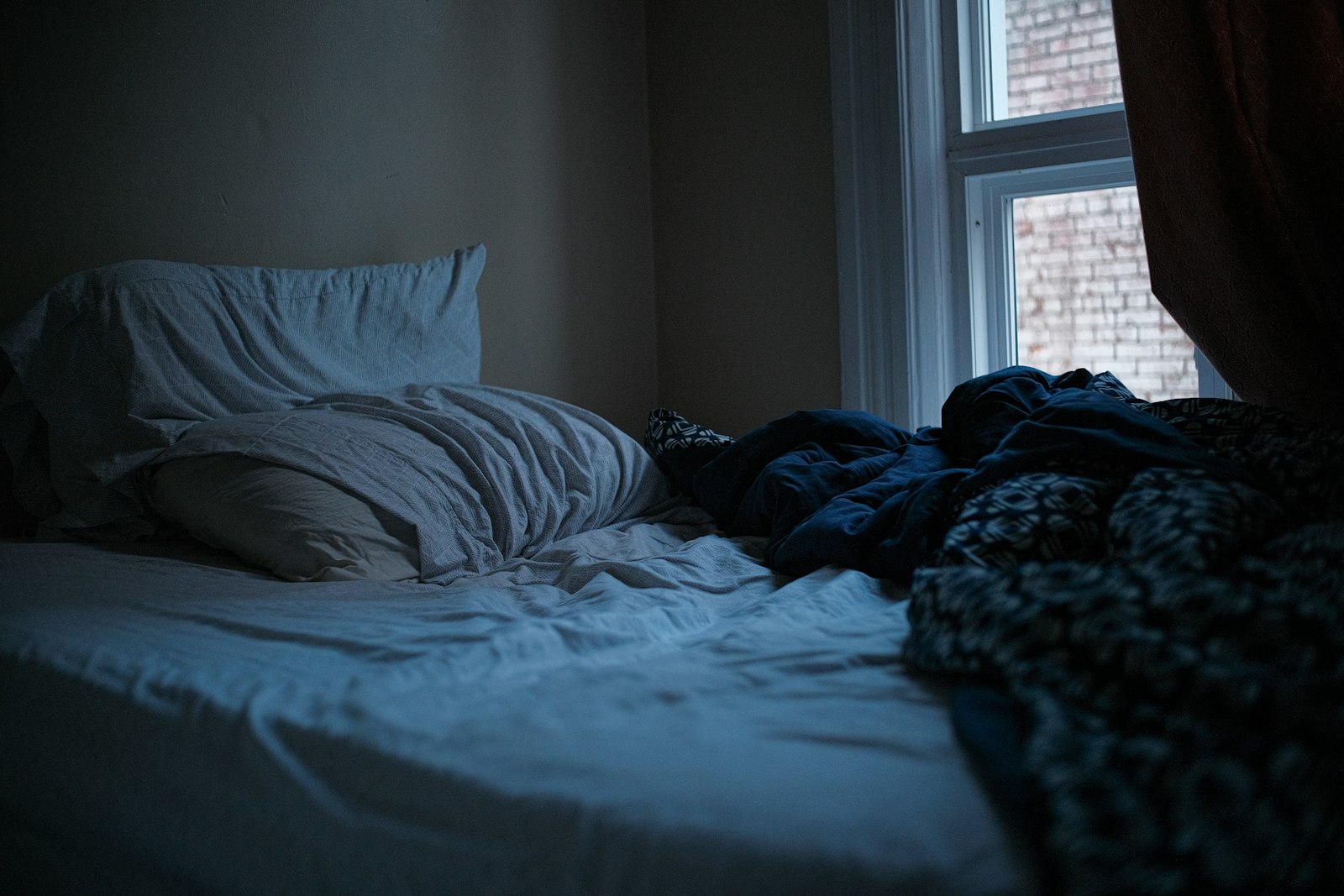 Lit défait dans une chambre au petit matin